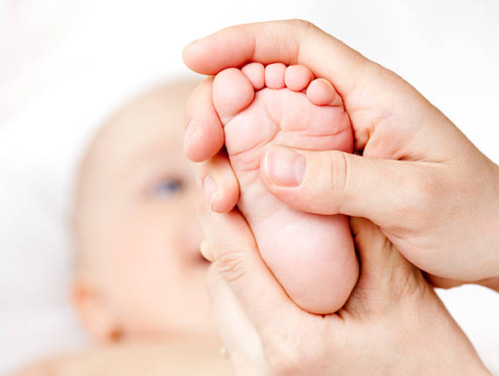 Un bébé se fait masser le pied